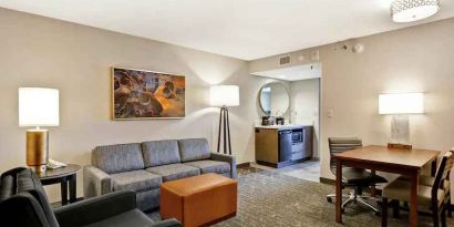 Comfortable living room with working station and sofa in a king suite at the Embassy Suites by Hilton Minneapolis-Airport.