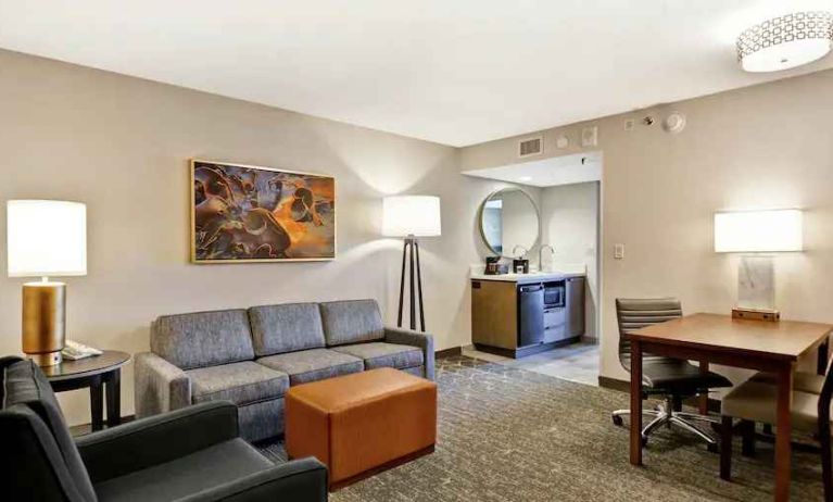 Comfortable living room with working station and sofa in a king suite at the Embassy Suites by Hilton Minneapolis-Airport.