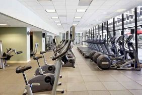 large, well-equipped fitness center with natural light at Hilton Atlanta.