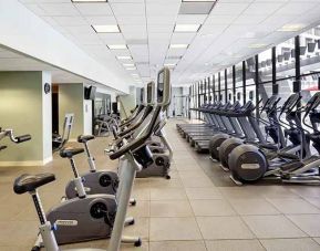 large, well-equipped fitness center with natural light at Hilton Atlanta.
