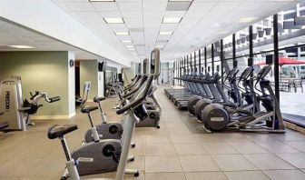 large, well-equipped fitness center with natural light at Hilton Atlanta.