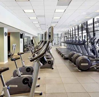 large, well-equipped fitness center with natural light at Hilton Atlanta.