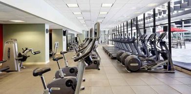 large, well-equipped fitness center with natural light at Hilton Atlanta.