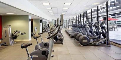 large, well-equipped fitness center with natural light at Hilton Atlanta.