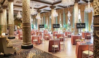 Elegant event room with big windows, lovely chandeliers and intricate pillars at The Drake.