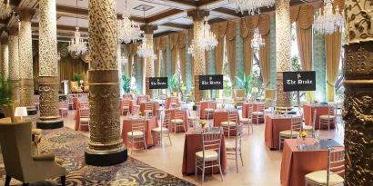 Elegant event room with big windows, chairs and tables at the Drake.