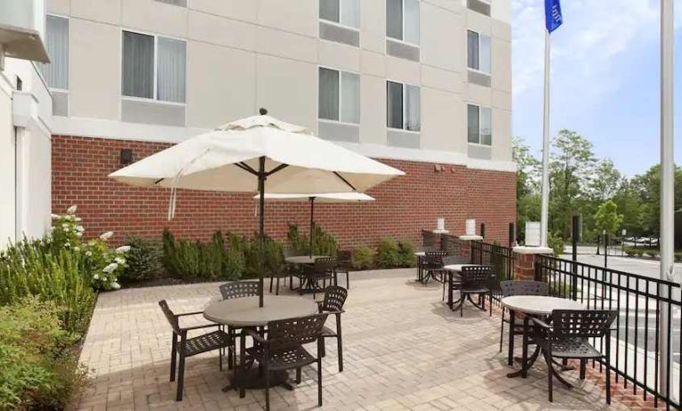 Outdoor patio with tables and chairs perfect as workspace at the Hilton Garden Inn Silver Spring White Oak.