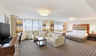 Beautiful king suite with desk, TV screen and sofa at the Hilton Crystal City at Washington Reagan National Airport.