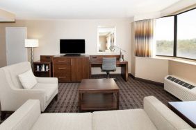 Sofa, TV screen and desk in a king suite at the Hilton Crystal City at Washington Reagan National Airport.