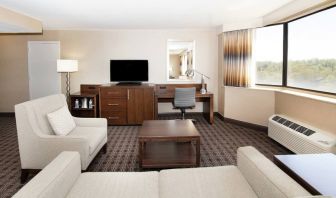 Sofa, TV screen and desk in a king suite at the Hilton Crystal City at Washington Reagan National Airport.