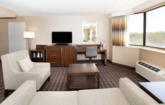 Sofa, TV screen and desk in a king suite at the Hilton Crystal City at Washington Reagan National Airport.