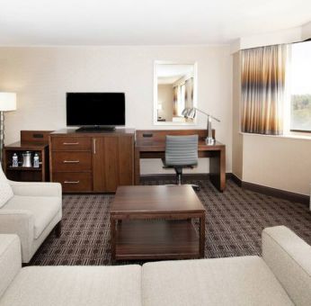 Sofa, TV screen and desk in a king suite at the Hilton Crystal City at Washington Reagan National Airport.