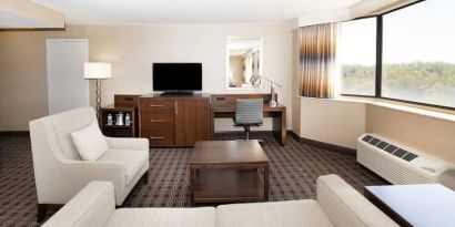 Sofa, TV screen and desk in a king suite at the Hilton Crystal City at Washington Reagan National Airport.