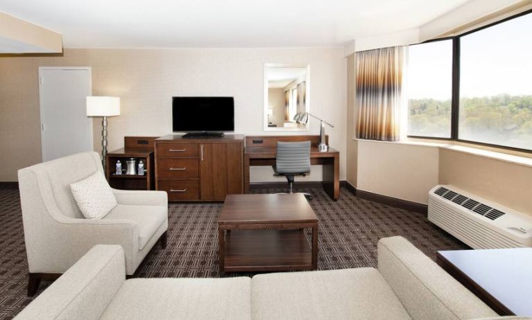 Sofa, TV screen and desk in a king suite at the Hilton Crystal City at Washington Reagan National Airport.