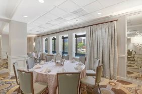 Elegant event room with chairs and tables at the Hilton Crystal City at Washington Reagan National Airport.