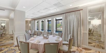 Elegant event room with chairs and tables at the Hilton Crystal City at Washington Reagan National Airport.