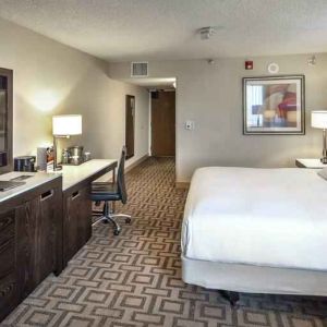 TV screen, desk and sofa in a king suite at the Hilton Sacramento-Arden West.