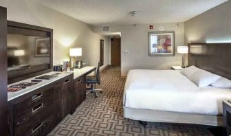 TV screen, desk and sofa in a king suite at the Hilton Sacramento-Arden West.