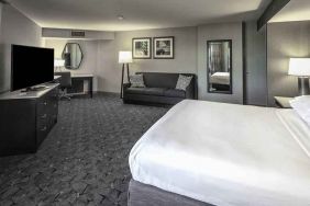 King size bed, sofa and desk in a spacious bedroom at the DoubleTree by Hilton Modesto.