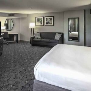 King size bed, sofa and desk in a spacious bedroom at the DoubleTree by Hilton Modesto.