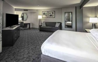 King size bed, sofa and desk in a spacious bedroom at the DoubleTree by Hilton Modesto.