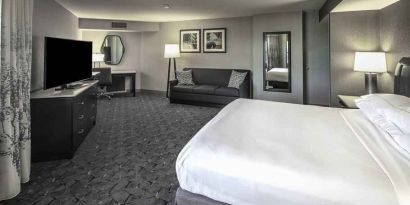 King size bed, sofa and desk in a spacious bedroom at the DoubleTree by Hilton Modesto.