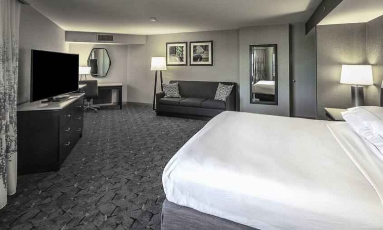 King size bed, sofa and desk in a spacious bedroom at the DoubleTree by Hilton Modesto.