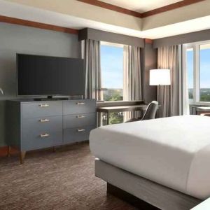 President suite with king size bed, desk and view at the Hilton Baltimore BWI Airport.