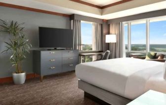 President suite with king size bed, desk and view at the Hilton Baltimore BWI Airport.