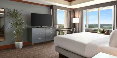 President suite with king size bed, desk and view at the Hilton Baltimore BWI Airport.