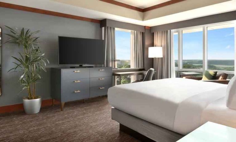 President suite with king size bed, desk and view at the Hilton Baltimore BWI Airport.