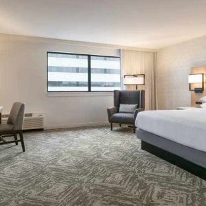 King size bed, TV screen and desk in a hotel room at the DoubleTree by Hilton Canton Downtown.