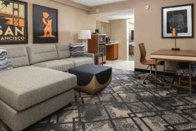 Living room with working station in a king suite at the Embassy Suites by Hilton San Francisco Airport.