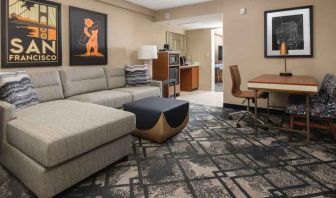 Living room with working station in a king suite at the Embassy Suites by Hilton San Francisco Airport.