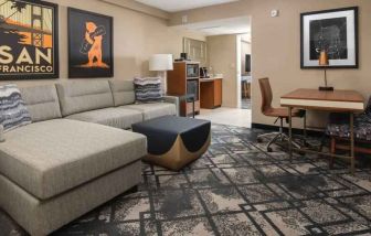 Living room with working station in a king suite at the Embassy Suites by Hilton San Francisco Airport.