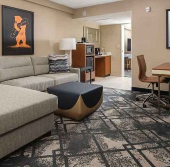 Living room with working station in a king suite at the Embassy Suites by Hilton San Francisco Airport.