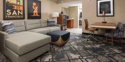 Living room with working station in a king suite at the Embassy Suites by Hilton San Francisco Airport.