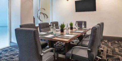 Small meeting room with TV screen at the Embassy Suites by Hilton San Francisco Airport.