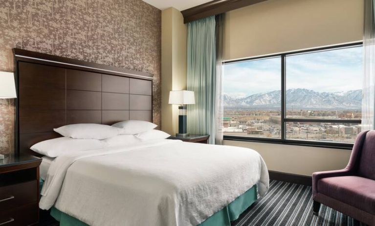 Bright king bedroom with large window at the Embassy Suites by Hilton Salt Lake City West Valley.