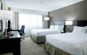 Spacious queen size room with 2 queen beds, desk, and chair at the Hilton Nashville Airport.