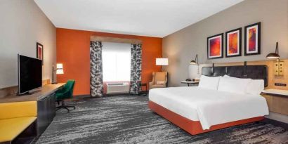 Spacious and comfortable king bedroom with window and TV screen at the Hilton Garden Inn Hays.