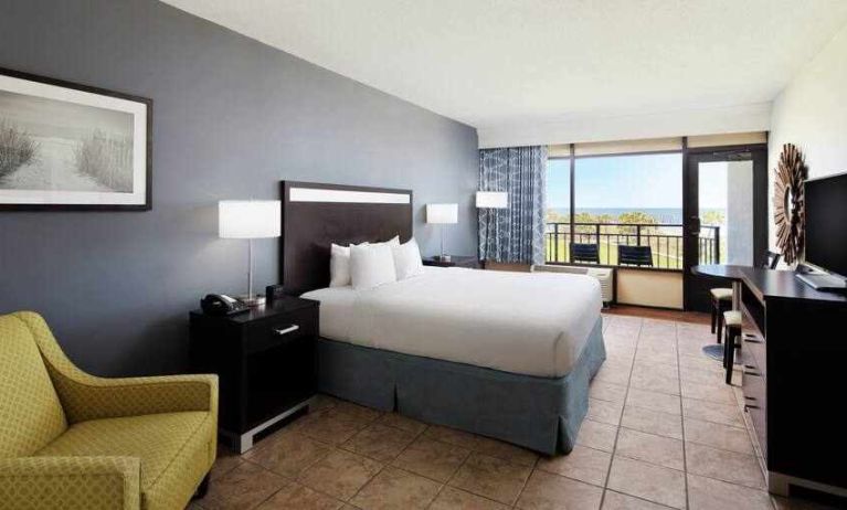 King bedroom with balcony and ocean view at the DoubleTree by Hilton Myrtle Beach.