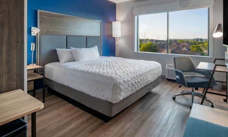 Spacious king bed with desk and chairs at the Tru by Hilton Omaha I-80 at 72nd Street.