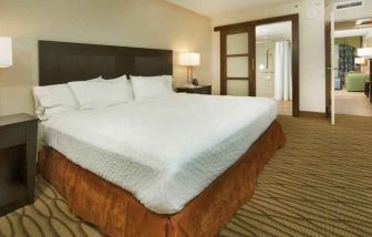 King size bed in a hotel suite at the Embassy Suites by Hilton Miami - International Airport.