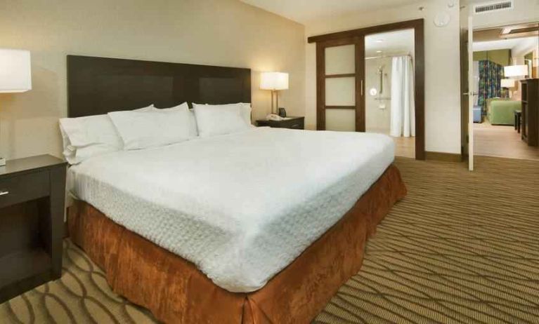 King size bed in a hotel suite at the Embassy Suites by Hilton Miami - International Airport.