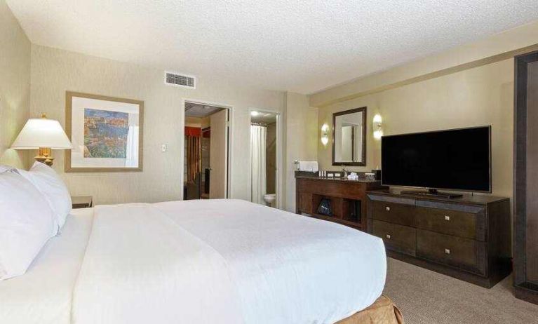 Comfortable king bedroom in a hotel suite at the Embassy Suites by Hilton Kansas City Plaza.