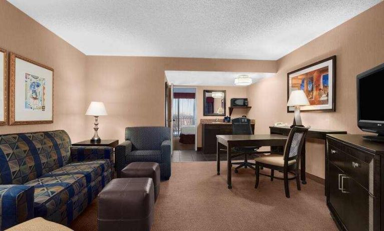 Spacious living area with working station in a king suite at the Embassy Suites by Hilton Kansas City Plaza.