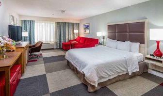 Spacious king room with work area and lounge at Hampton Inn San Francisco Airport.