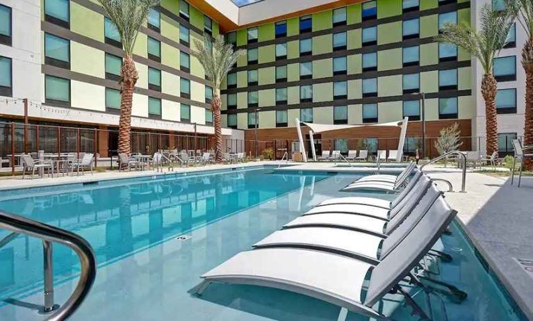 beautiful outdoor pool with seating and sun beds at Hampton Inn & Suites Las Vegas Convention Center.