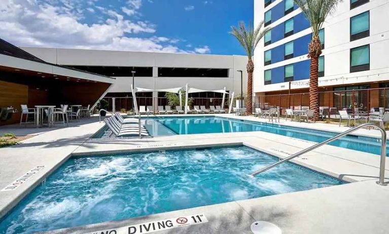 beautiful outdoor pool with seating and sun beds at Hampton Inn & Suites Las Vegas Convention Center.